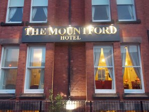 Fasaden på The Mountford Hotel med en tydlig skylt ovanför ingången.