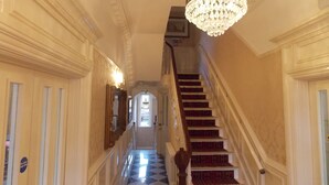 A grand hallway with a chandelier, a checkered floor, and a staircase with red carpet. - The Mountford Hotel - Free Parking (Liverpool)