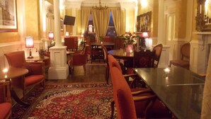 A hotel lobby with a round table, red chairs, a patterned carpet, and a chandelier. - The Mountford Hotel - Free Parking (Liverpool)