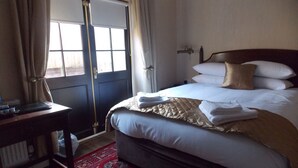 A hotel room with a bed, a desk, a chair, a window with curtains, and a door. - The Mountford Hotel - Free Parking (Liverpool)