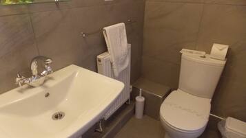 Ein Badezimmer mit Waschbecken, Toilette und Handtuchhalter.