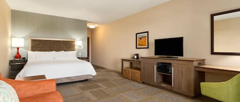 Ein Hotelzimmer mit Bett, Schreibtisch, Fernseher, Stuhl und Lampe.