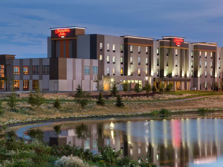 Un hotel moderno con tetto piatto, diversi piani e una insegna che indica Hampton Inn.