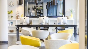 A modern dining area with a long table, multiple chairs, and overhead lighting.