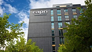 A modern building with the sign "Capri Hotel Residences" by Fraser.