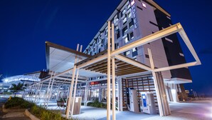 A modern hotel with a prominent 'HOTEL' sign, a covered entrance, and a visible 'Mark' sign in the background. - ibis Mackay (South Mackay)