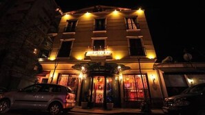 A hotel with a classic facade, multiple windows, and a well-lit entrance. - Dream Hotel (Tirana)