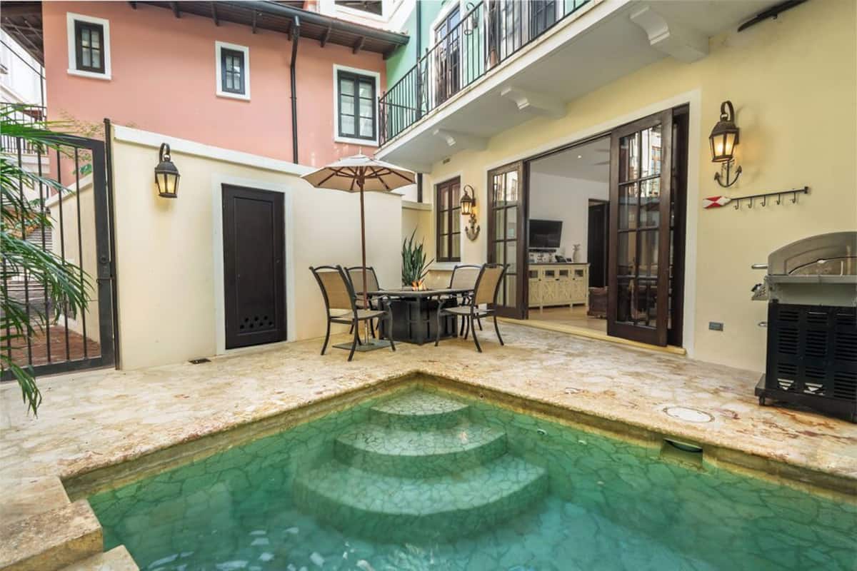 Un patio con piscina, mobiliario exterior y zona de barbacoa.