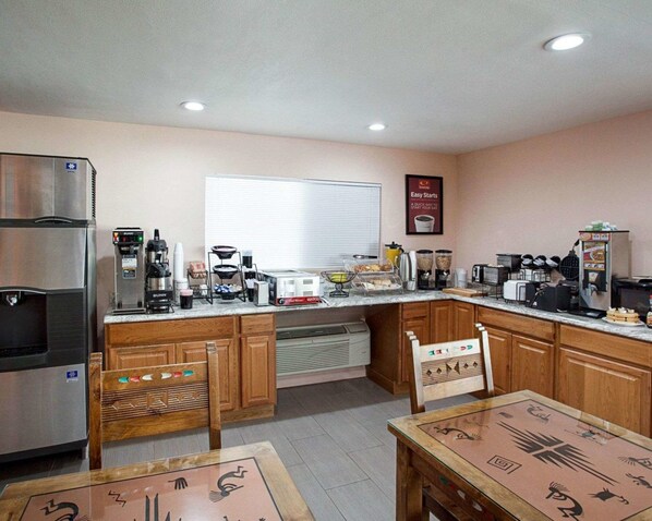 A compact kitchen with a refrigerator, coffee maker, and a microwave.