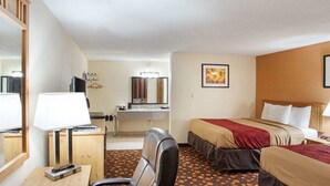 A hotel room with a desk, chair, two beds, a bathroom, and a mirror. - Econo Lodge Phillipsburg (Phillipsburg)