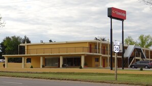 A two-story motel with a yellow facade, a balcony on the second floor, and a sign for EconoLodge. - Econo Lodge Phillipsburg (Phillipsburg)