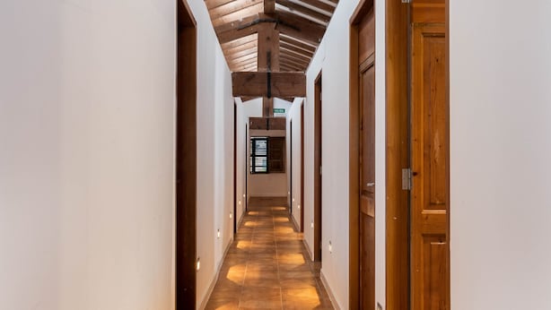 A long, narrow hallway with wooden beams on the ceiling and a tiled floor. - Urban Hostel Palma Albergue Juvenil (Palma de Mallorca)