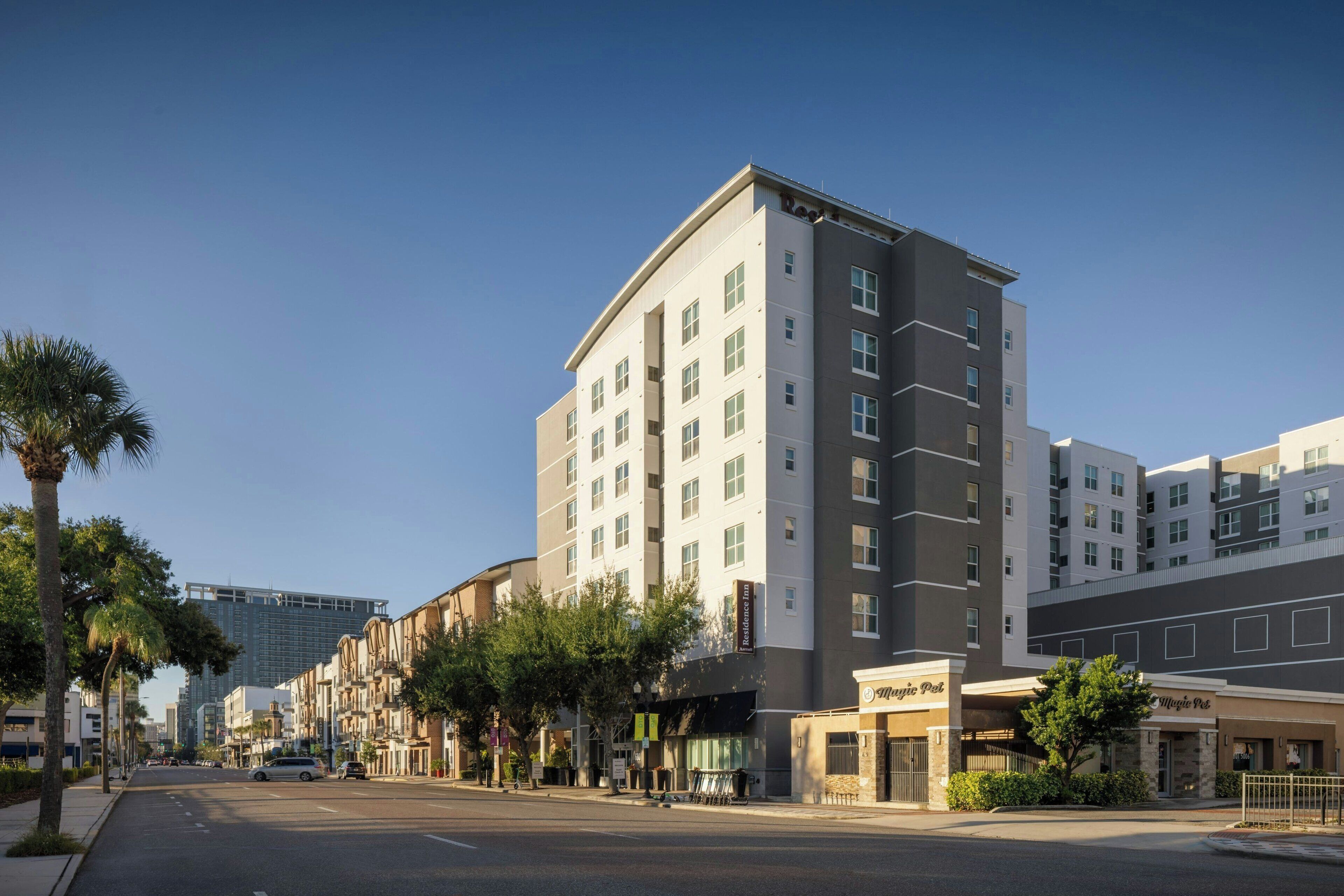 Un hôtel à plusieurs étages au design moderne, doté d’une entrée imposante et offrant une vue dégagée sur la rue.