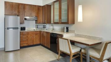 A modern kitchen with wooden cabinets, stainless steel appliances, and a granite countertop.
