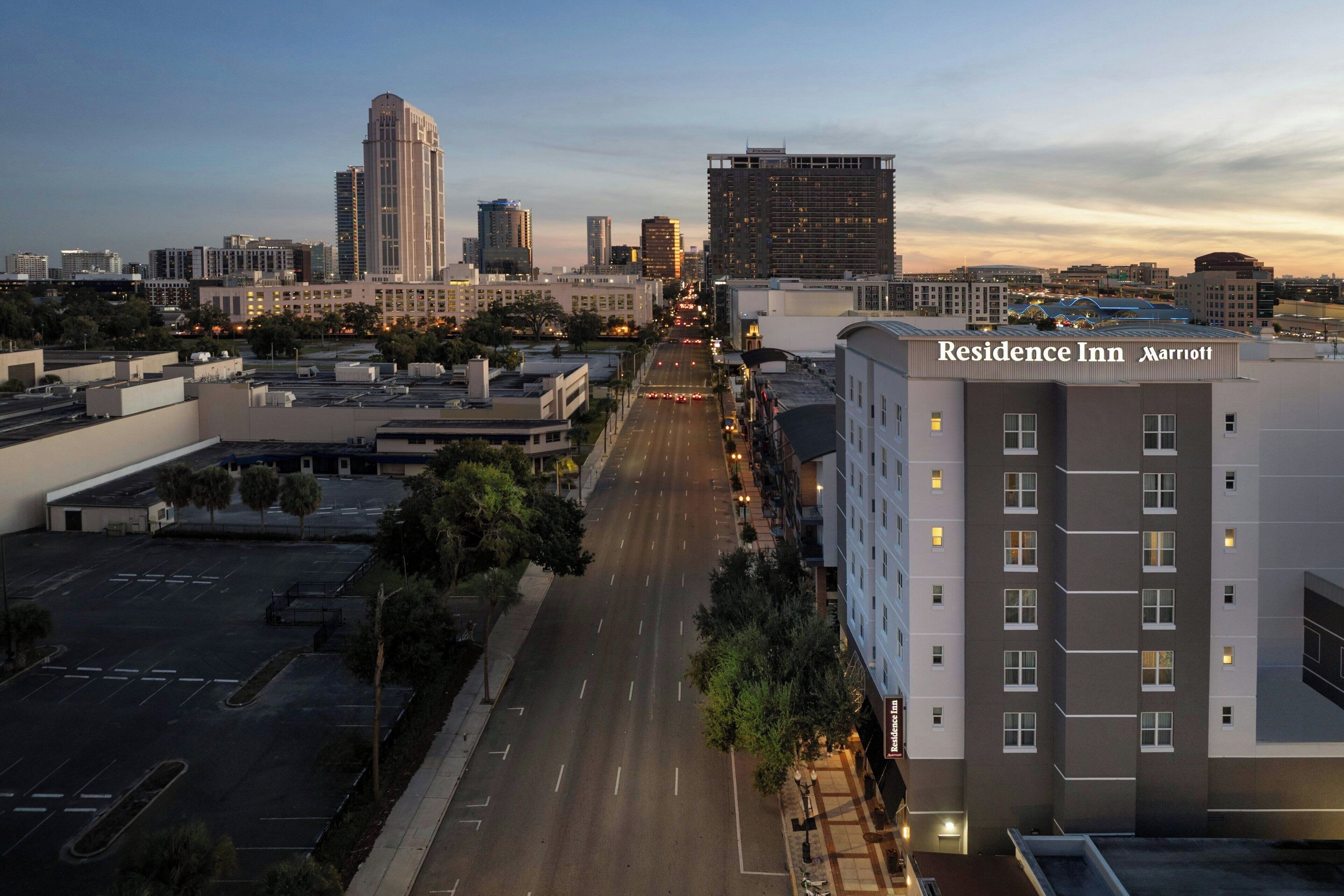 A multi-story hotel with a clear view of the city skyline in the background.