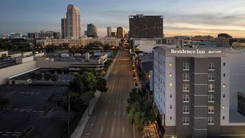 A multi-story hotel with a clear view of the city skyline in the background.