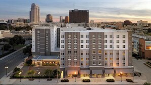 A multi-story hotel with a modern design, featuring a mix of residential and commercial spaces, situated in an urban area with a view of the city skyline. - Residence Inn by Marriott Orlando Downtown (Orlando)