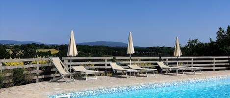 Seasonal outdoor pool, open 9:00 AM to 8:00 PM, pool umbrellas