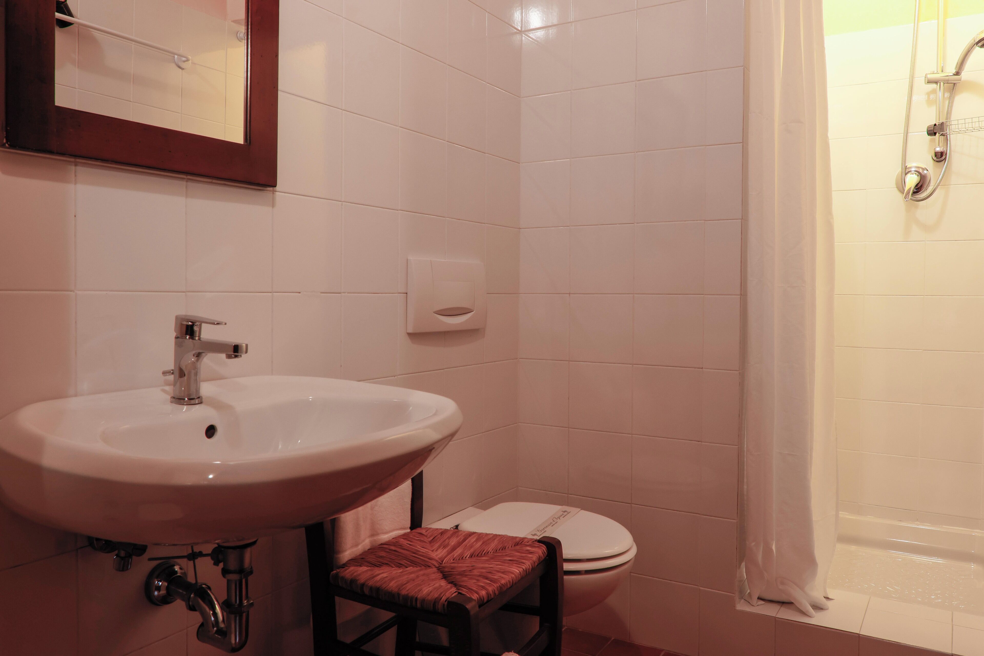 Un baño con lavamanos, inodoro y ducha.
