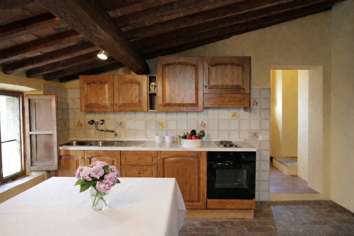 Una cocina con armarios de madera, encimera blanca, un lavabo y lavavajillas.
