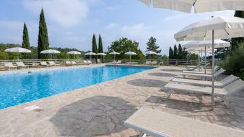 Een seizoensgebonden buitenzwembad, parasols voor strand/zwembad