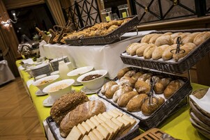 Una mesa de buffet con panes y pasteles varios.