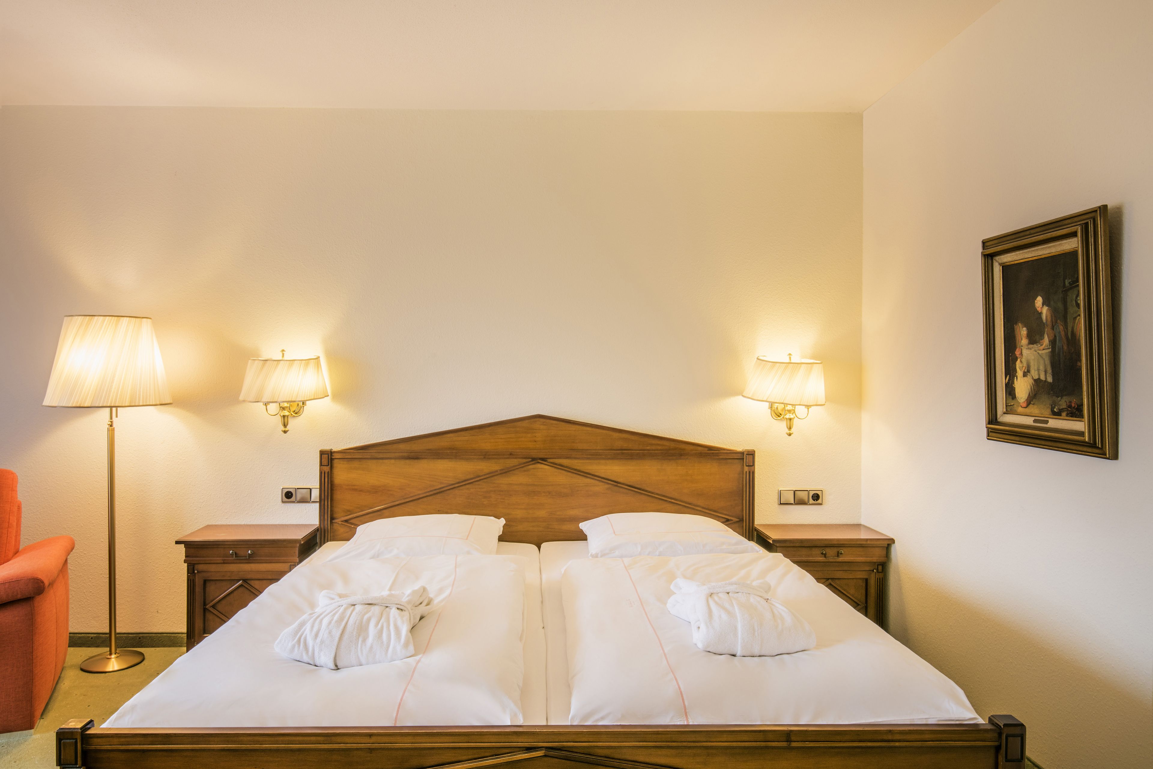 Un letto matrimoniale con due comodini, ognuno dotato di una lampada, in una camera d'albergo.