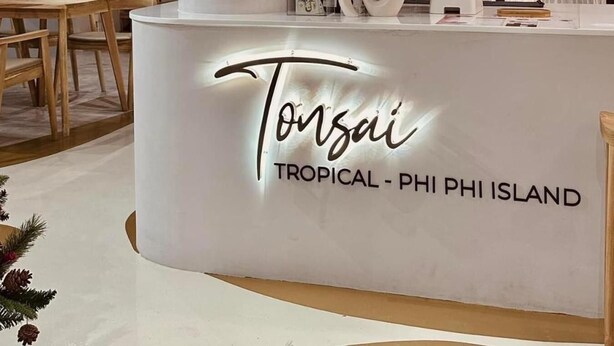 A reception desk with a sign reading 'Tonsai Tropical - Phi Phi Island.'
