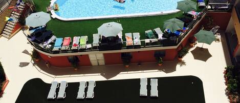 Ein Poolbereich auf dem Dach mit Liegestühlen und Sonnenschirmen.