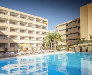 Alberca al aire libre y camastros