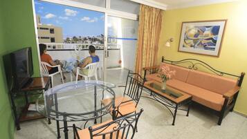 Apartment, Balcony, Pool View | Living room | Flat-screen TV