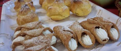 A plate of cream puffs and profiteroles on a table.