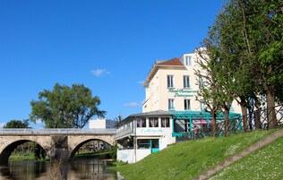 A riverside hotel with a bridge, a restaurant, and a view of the water.