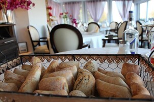 A dining area with a basket of baguettes.