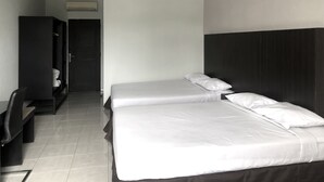A hotel room with a bed, a desk, and a wardrobe. - Hotel Sinar 3 (Sidoarjo)