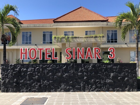 Et hotelskilt med "HOTEL SINAR 3" i store bogstaver.