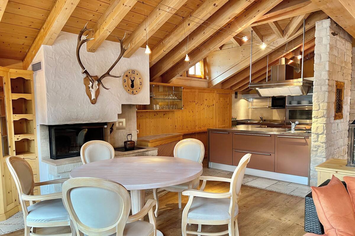 Eine rustikale Küche mit Holzbalken, einer Steinwand und einem Kamin.