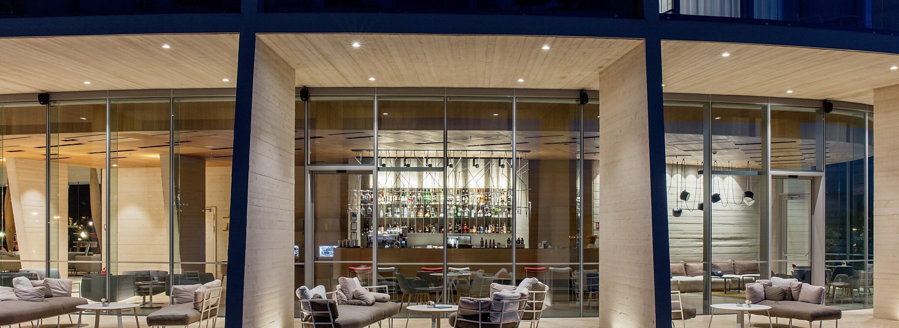 A modern bar area with glass walls, seating, and a visible bar counter.