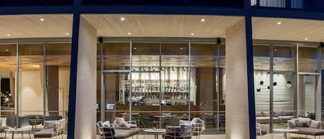 A modern bar area with glass walls, seating, and a visible bar counter.