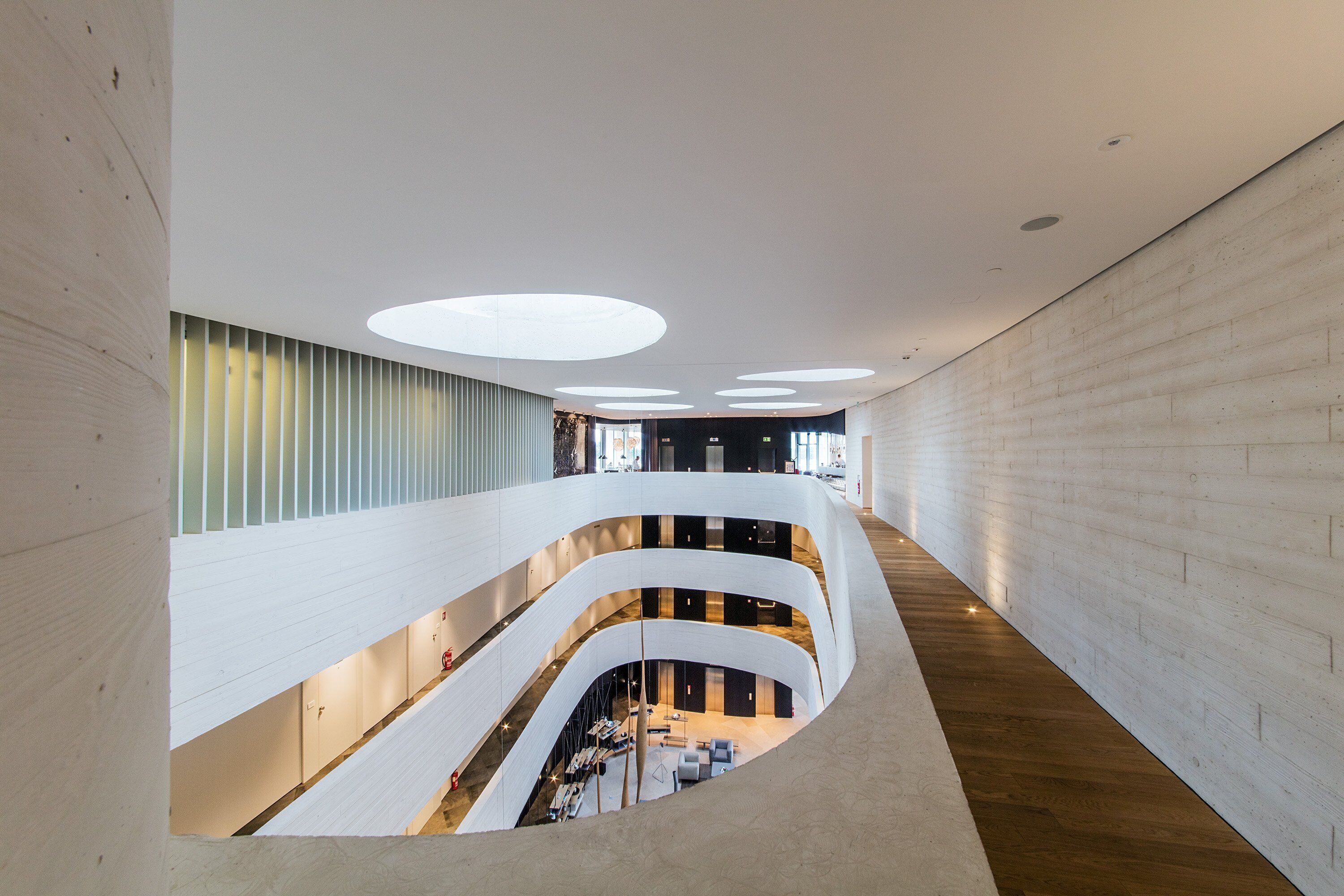 Un intérieur moderne avec un escalier à volutes, plusieurs niveaux et un éclairage encastré.