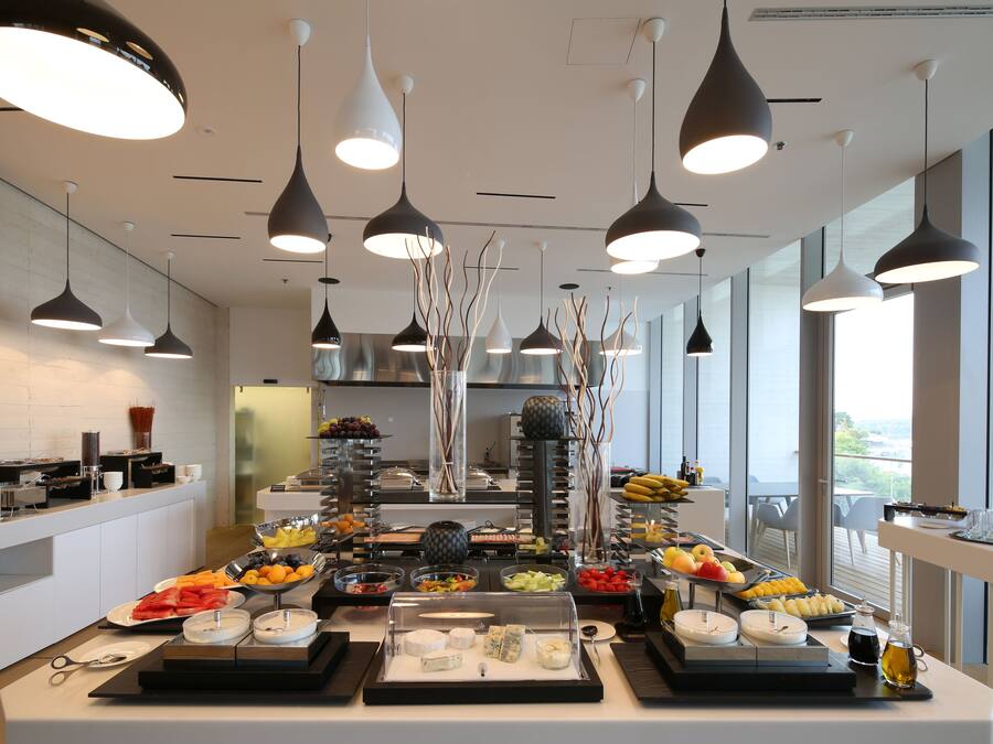 A buffet with various food items and a clear view of the kitchen area.