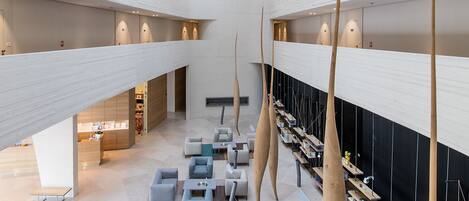A spacious, multi-level atrium with modern furniture and unique lighting fixtures.