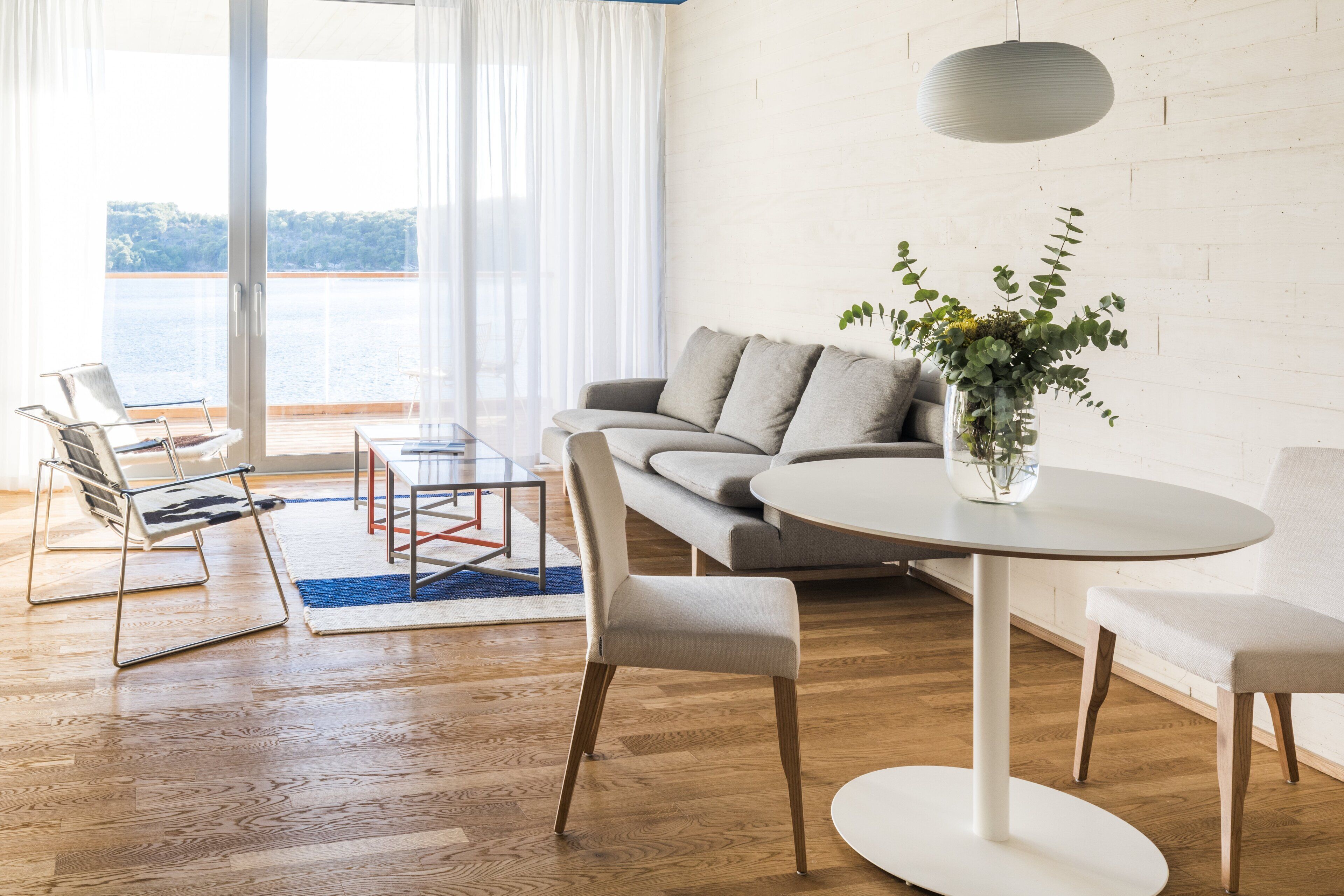 Una sala moderna con un sofá, una mesa redonda y una silla.