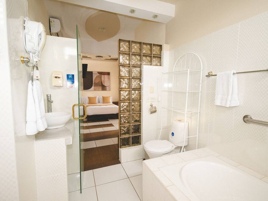 A modern bathroom with a glass shower enclosure, a bathtub, and a toilet.