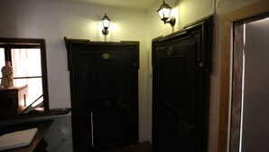 A hallway with two dark wooden doors, each with a light fixture above. - Haus Wartenberg (Salzburg)