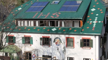 A building with a green roof, multiple windows, and a visible sign with the number 2.