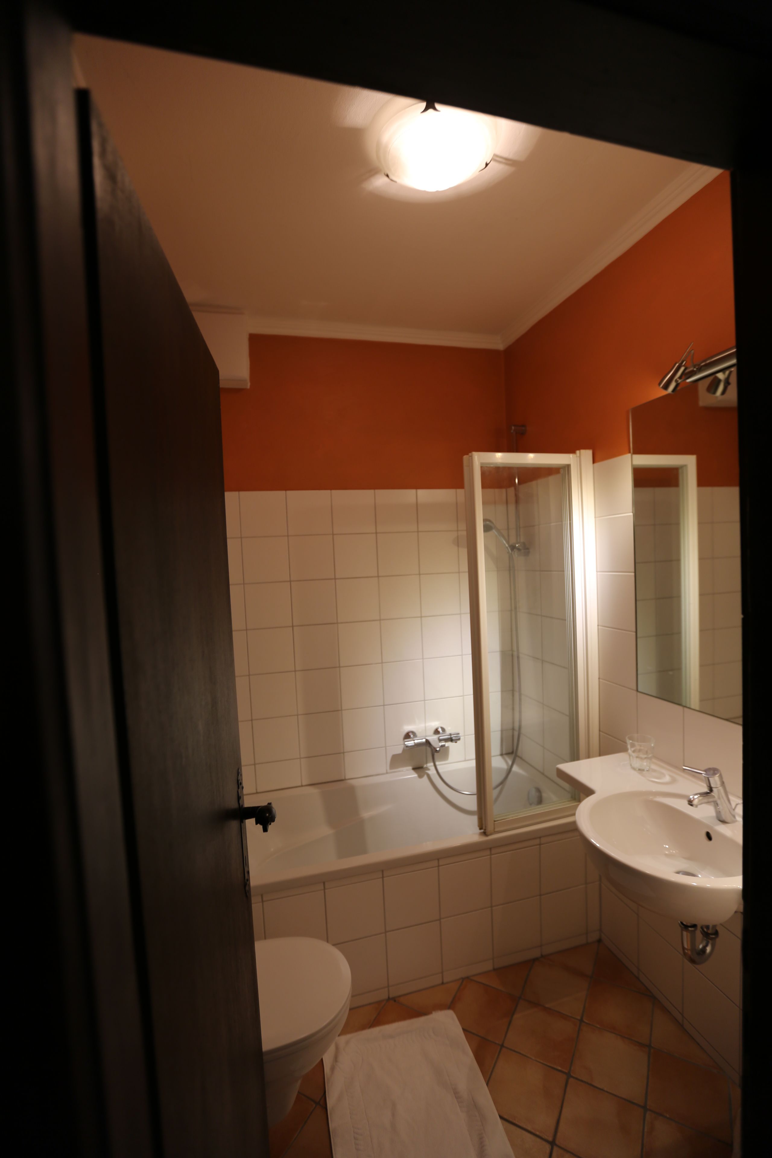 A bathroom with a toilet, bathtub, and two sinks.