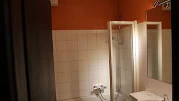 A bathroom with a toilet, bathtub, and two sinks.