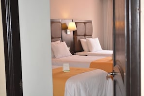 A hotel room with two beds, a nightstand, and a lamp. - La Casa de Don Ignacio (Cusco)
