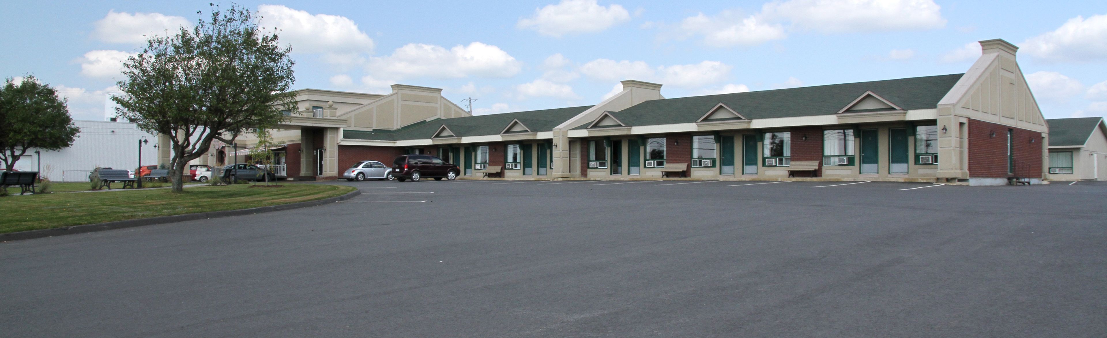 A commercial building with a parking lot and a few cars.
